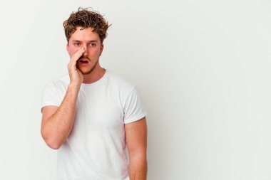 Beyaz arka planda izole edilmiş genç beyaz bir adam gizli bir sıcak fren haberi veriyor ve yana bakıyor.