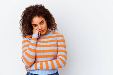 Beyaz arka planda izole edilmiş genç Afrikalı Amerikalı kadın üzgün ve dalgın hisseder, fotokopi alanına bakar..