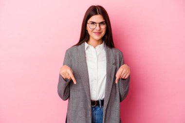 Kafkasyalı genç iş kadını pembe arka planda izole edilmiş parmakları aşağıda, olumlu hisler içinde..