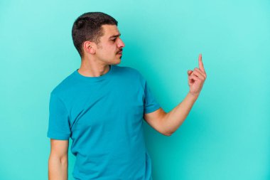 Kafkasyalı genç adam mavi arka planda izole edilmiş seni işaret ediyor sanki davet ediliyormuş gibi..