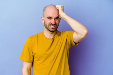 Kafkasyalı kel adam mor arka planda izole edilmiş bir şekilde bir şeyi unutuyor. Alnına avuç içi ve gözlerini kapayarak vuruyor..