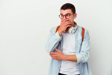 Beyaz arka planda izole edilmiş müzik dinleyen beyaz tenli genç bir öğrenci. Ağzını eliyle kapatan bir fotokopi odasına dikkatlice bakıyor..