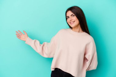 Mavi arka planda izole edilmiş beyaz bir kadın hoş bir ifade sergiliyor..