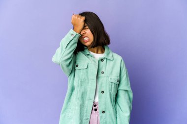 Genç melez kadın bir şeyi unutuyor. Alnına avuç içi ve kapalı gözlerle vuruyor..