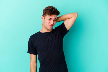 Kafkasyalı genç bir adam mavi arka planda izole edilmiş. Durağan yaşam tarzından dolayı boyun ağrısı çekiyor..