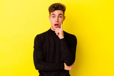 Sarı arka planda izole edilmiş genç beyaz bir adam harika bir fikri, yaratıcılık kavramı var..