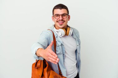 Beyaz arka planda izole edilmiş müzik dinleyen beyaz tenli genç bir öğrenci selamlama jesti olarak kameraya elini uzatıyor..