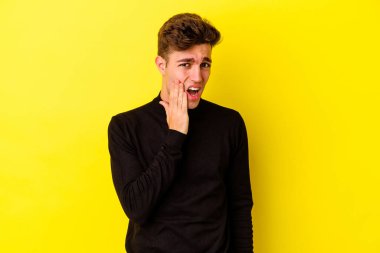 Sarı arka planda izole genç beyaz adam güçlü bir diş ağrısı, azıdişi ağrısı var..