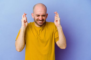 Kafkasyalı kel adam mor arka planda izole edilmiş şans dilemek için şans diliyor.