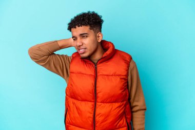 Genç Afro-Amerikan kıvırcık adamı sakin yaşam tarzından dolayı boyun ağrısı çeken mavi renkte izole edilmiş..