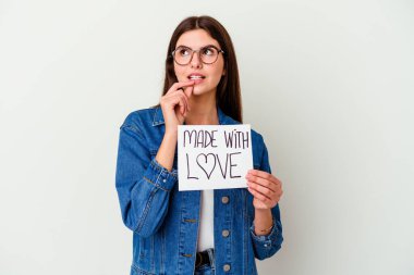 Beyaz arka planda izole edilmiş aşk tabelasıyla yapılmış beyaz bir kadın şüpheli ve şüpheci bir ifadeyle yan yana bakıyor..