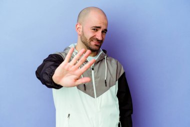 Mor arka planda izole edilmiş beyaz kel bir adam iğrenme hareketi gösteren birini reddediyor..