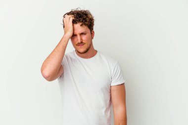 Beyaz arka planda izole edilmiş genç beyaz bir adam bir şeyi unutuyor. Alnına avuç içi ve gözlerini kapayarak vuruyor..