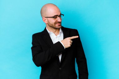 Mavi arka planda soyutlanmış beyaz saçlı genç adam gülümsüyor, neşeli ve keyifli görünüyor..