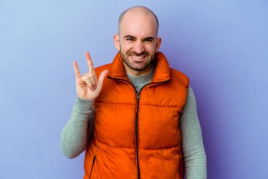 Mor arka planda izole edilmiş beyaz, kel bir adam parmaklarıyla taş hareketi gösteriyor.