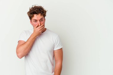 Beyaz arka planda izole edilmiş beyaz tenli genç adam ağzını eliyle kapatan bir fotokopi odasına bakıyor..