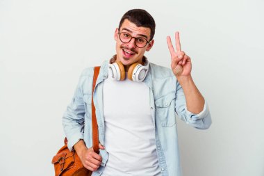 Beyaz arka planda izole edilmiş müzik dinleyen beyaz tenli genç beyaz bir öğrenci neşeli ve tasasız parmakları olan bir barış sembolü gösteriyor..