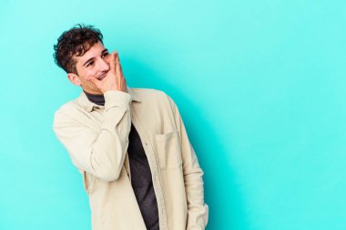 Kafkasyalı genç adam mavi arka planda yalnızdı gülerek, kaygısızca, doğal duygularla.