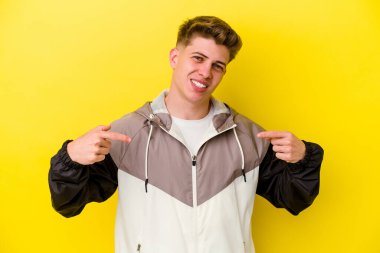 Sarı arka planda izole edilmiş genç beyaz adam parmakları aşağıda, olumlu bir his var..