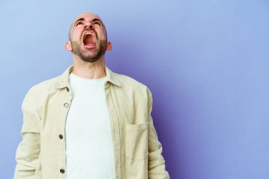 Kafkasyalı genç kel adam mor arka planda izole edilmiş çok kızgın, öfkeli, hayal kırıklığına uğramış.
