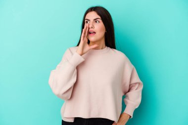 Mavi arka planda izole edilmiş beyaz bir kadın heyecanlı bir şekilde bağırıyor..