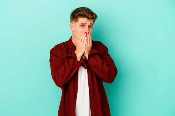 Νεαρός Καυκάσιος Άνδρας Απομονωμένος Μπλε Φόντο Σοκαρισμένος Που Καλύπτει Στόμα — Φωτογραφία Αρχείου