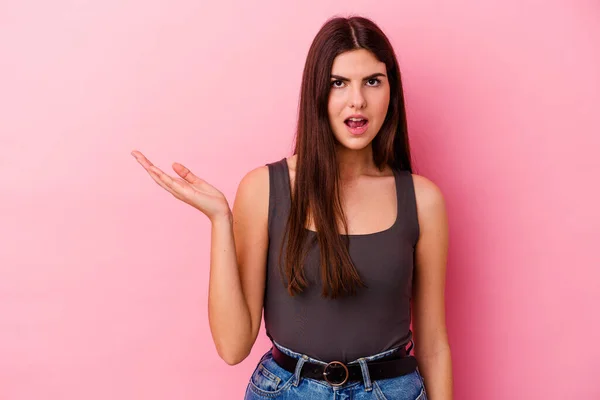 Jovem Mulher Caucasiana Isolado Fundo Rosa Impressionado Segurando Espaço Cópia — Fotografia de Stock