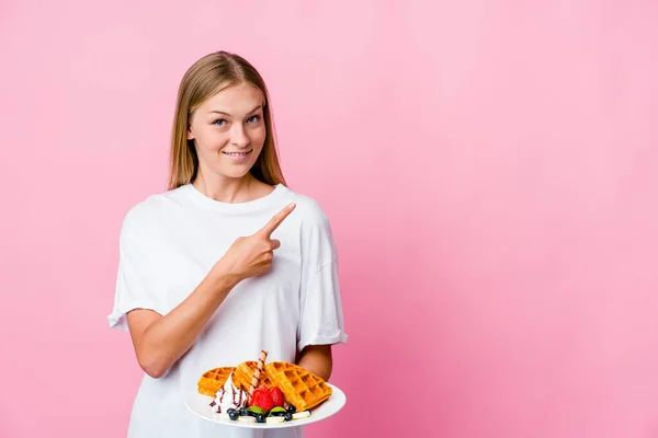 Young Russian Woman Eating Waffle Isolated Smiling Pointing Aside Showing — Stock Photo, Image