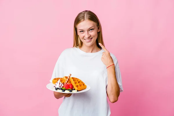 Mujer Rusa Joven Comiendo Waffle Sonríe Aislada Señalando Con Los — Foto de Stock