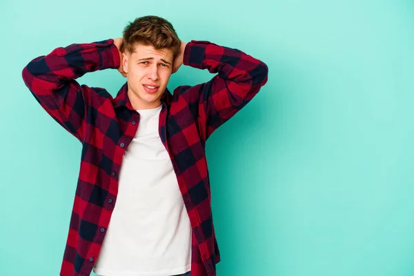 Joven Hombre Caucásico Aislado Sobre Fondo Azul Tocando Parte Posterior —  Fotos de Stock