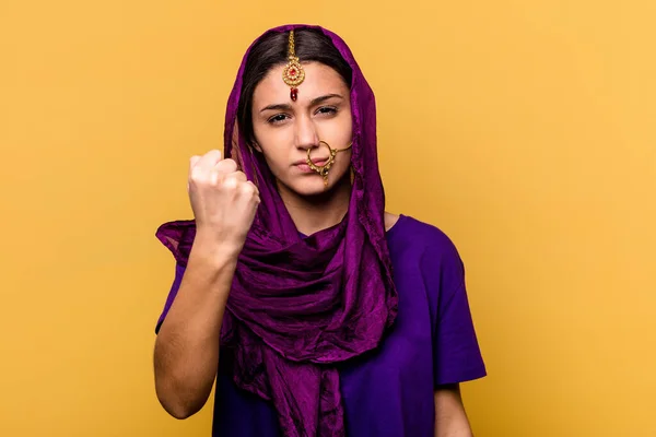 若いインド人女性はカメラに拳を示す黄色の背景に隔離された伝統的なサリーの服を着て 積極的な顔の表情 — ストック写真