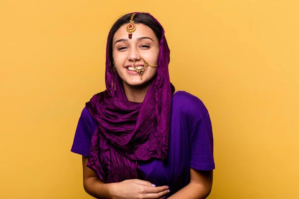 若いですインド人女性を身に着けています伝統的なサリーの服黄色の背景に孤立笑いと楽しみを持って — ストック写真