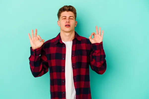 Joven Hombre Caucásico Aislado Sobre Fondo Azul Relaja Después Duro —  Fotos de Stock