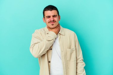 Mavi arka planda izole edilmiş genç beyaz adam virüs ya da enfeksiyon yüzünden boğazında ağrı hissediyor..
