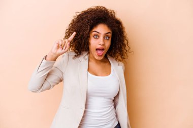 Genç Afrikalı Amerikalı kadın bej arka planda izole edilmiş. Harika bir fikri var, yaratıcılık kavramı..