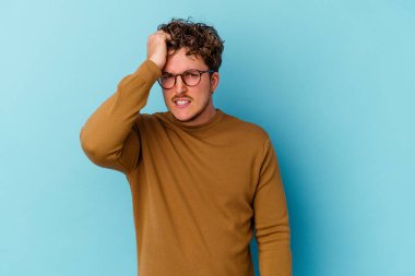 Mavi arka planda gözlük takan genç beyaz adam bir şeyi unutuyor. Alnına avuç içi ve kapalı gözlerle vuruyor..