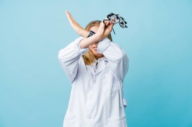 Mavili genç Rus optometrist kadın iki kolu çapraz tutuyor, inkar kavramı.