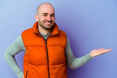 Mor arka planda izole edilmiş beyaz kel bir adam hoş bir yüz ifadesi sergiliyor..