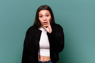 Mavi arka planda izole edilmiş genç Hintli kadın gizli bir sıcak fren haberinin olduğunu söylüyor.