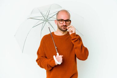 Genç kel bir adam şemsiye tutuyor. Parmakları dudaklarında ve bir sırrı saklıyor..