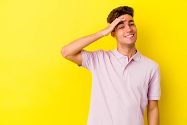 Sarı arka planda izole edilmiş genç beyaz adam gülüyor, kaygısız, doğal duygu..