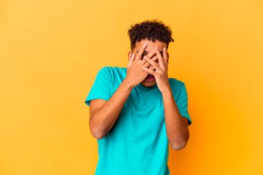 Genç Afro-Amerikalı kıvırcık adam, mor göz açıp kapayıncaya kadar izole edildi parmaklarıyla kameraya, utanarak yüzünü kapattı..