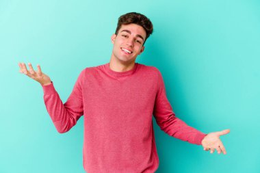 Mavi arka planda izole edilmiş beyaz bir genç hoş bir yüz ifadesi sergiliyor..