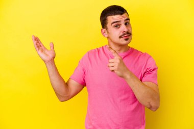 Sarı arka planda izole edilmiş beyaz bir adam elinde bir ürün tutuyor..