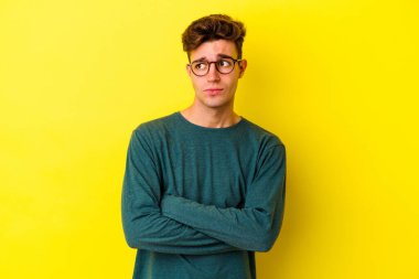 Sarı arka planda izole edilmiş genç beyaz adam hedeflere ve amaçlara ulaşma hayali kuruyor.