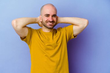 Mor arka planda izole edilmiş genç, beyaz kel bir adam. Kollarını uzatıyor, rahat bir konumda..
