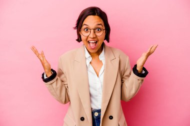Pembe arka planda izole edilmiş genç iş kadını hoş bir sürpriz alıyor, heyecanlı ve el kaldırıyor..