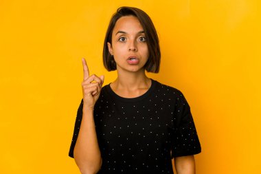 Genç İspanyol kadın sarıda izole edilmiş. Harika bir fikri var. Yaratıcılık kavramı..