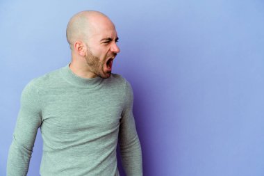 Kafkasyalı genç kel adam mor arka planda izole edilmiş çok kızgın, öfkeli, hayal kırıklığına uğramış.