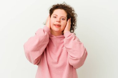 Down sendromlu bir kadın kulaklarını elleriyle kapatıyor ve yüksek sesli sesler duymamaya çalışıyor..